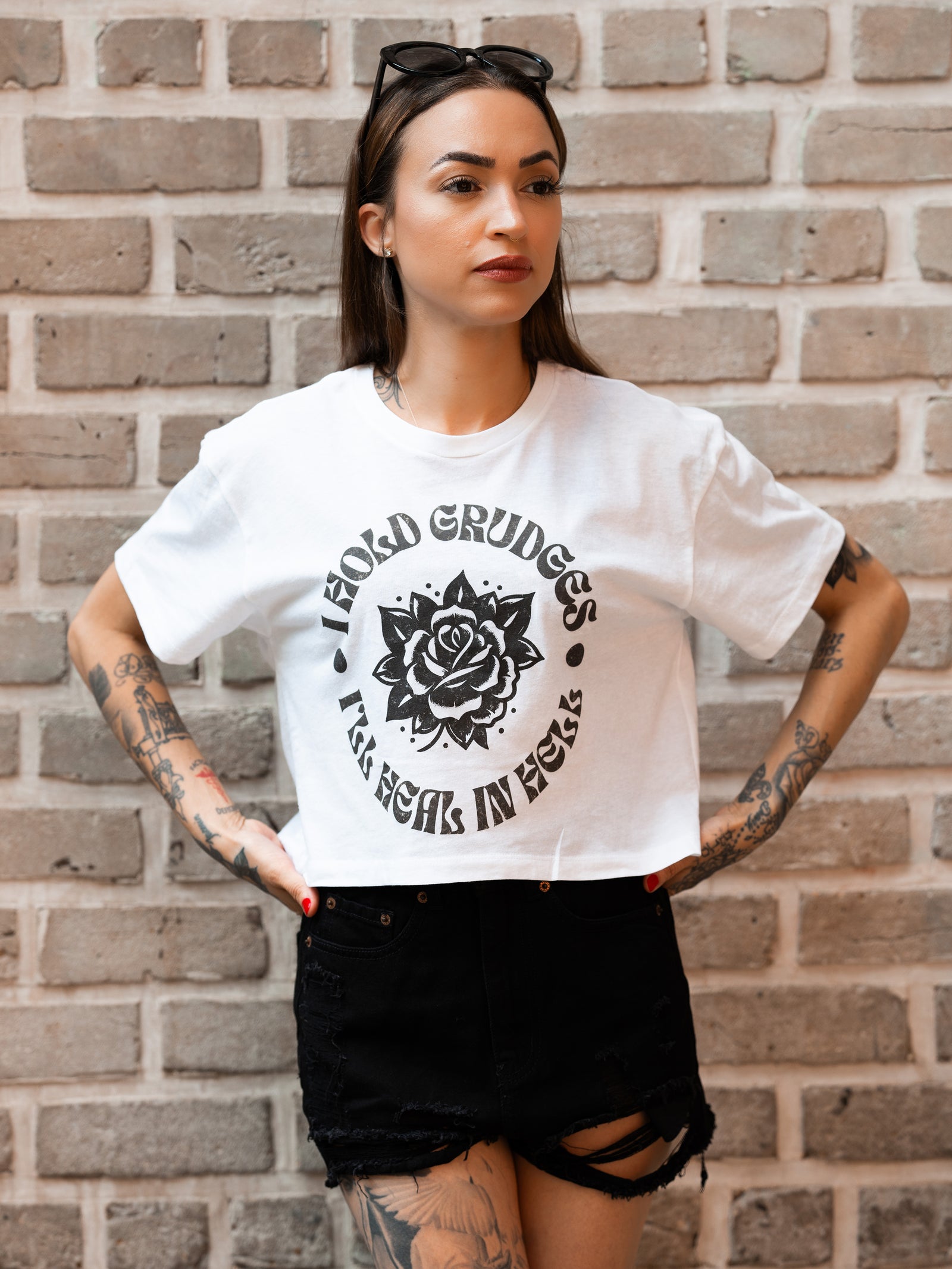 Janice Danger wearing the I Hold Grudges white oversize crop top with black denim shorts