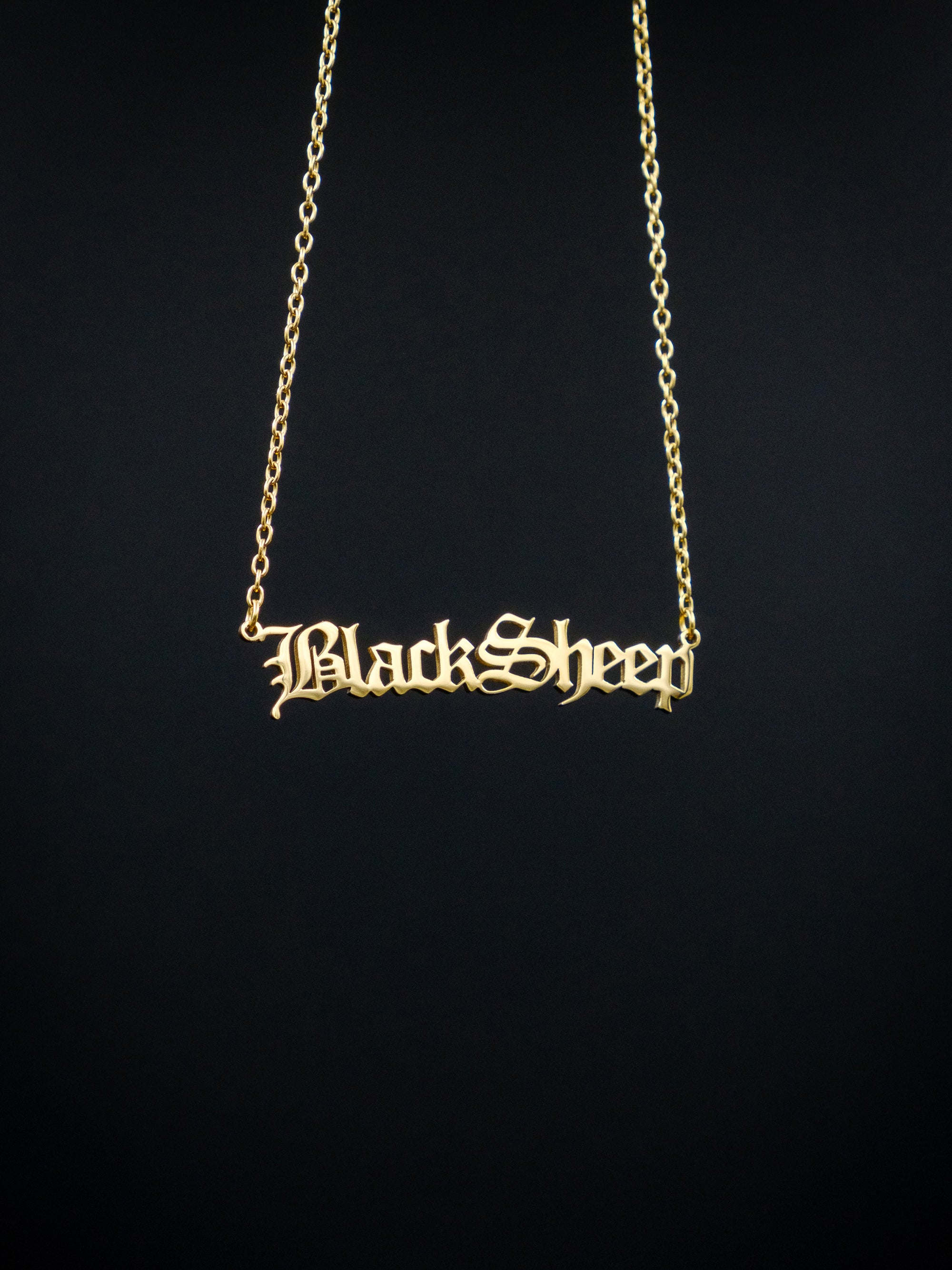 gold nameplate style necklace against a black background, reads BlackSheep in old english style font