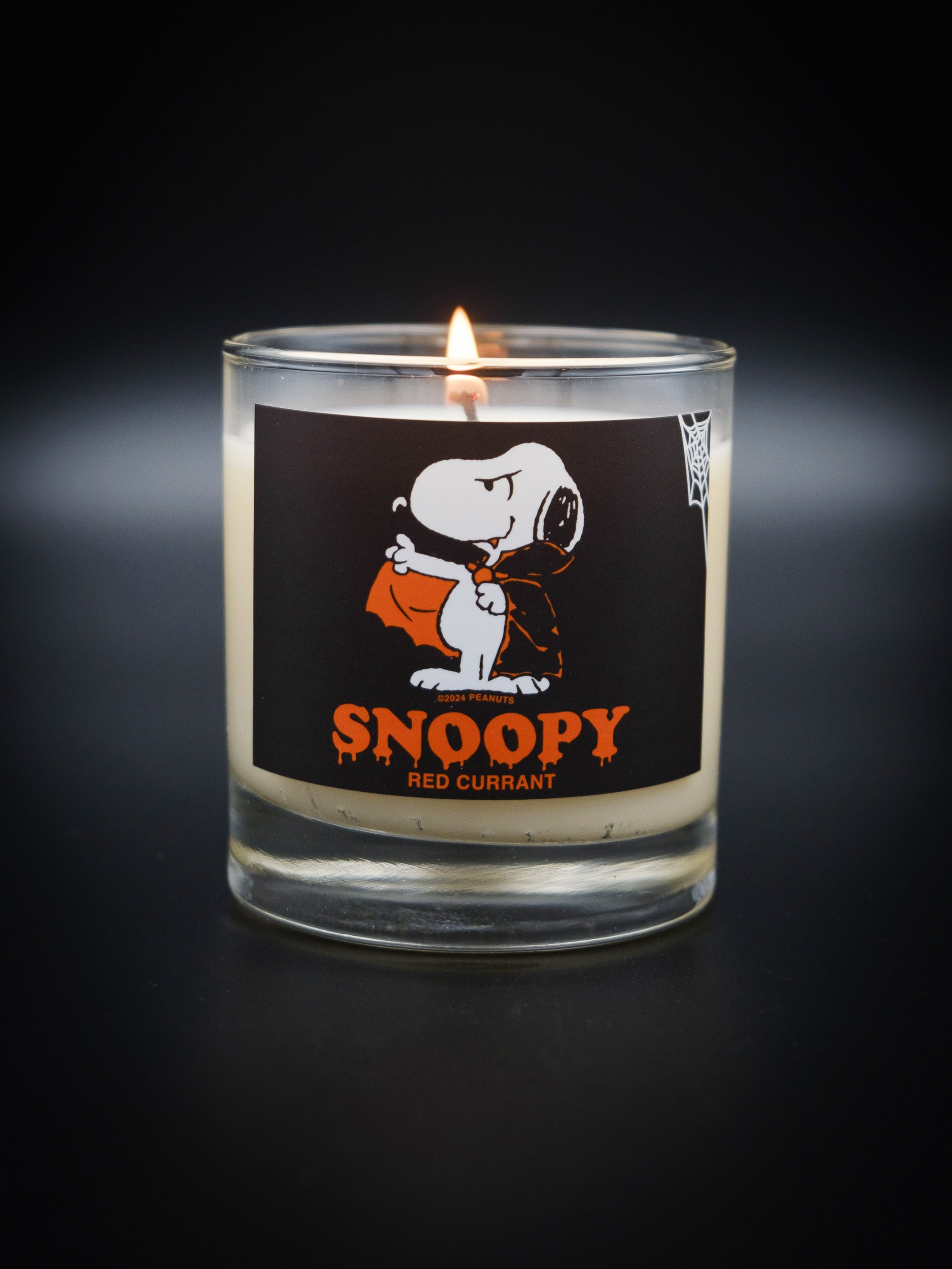 Lit votive Snoopy Candle. This candle features a drippy halloween themed Snoopy text with vampire Snoopy graphic. 