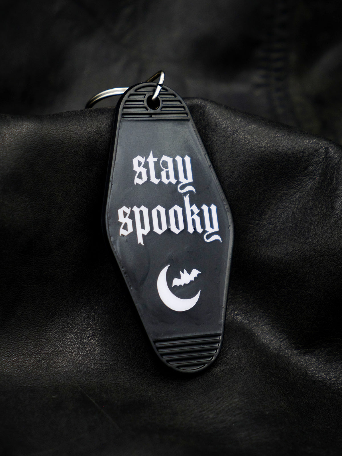 Black motel style keychain reads stay spooky in white with crescent moon and bat graphic