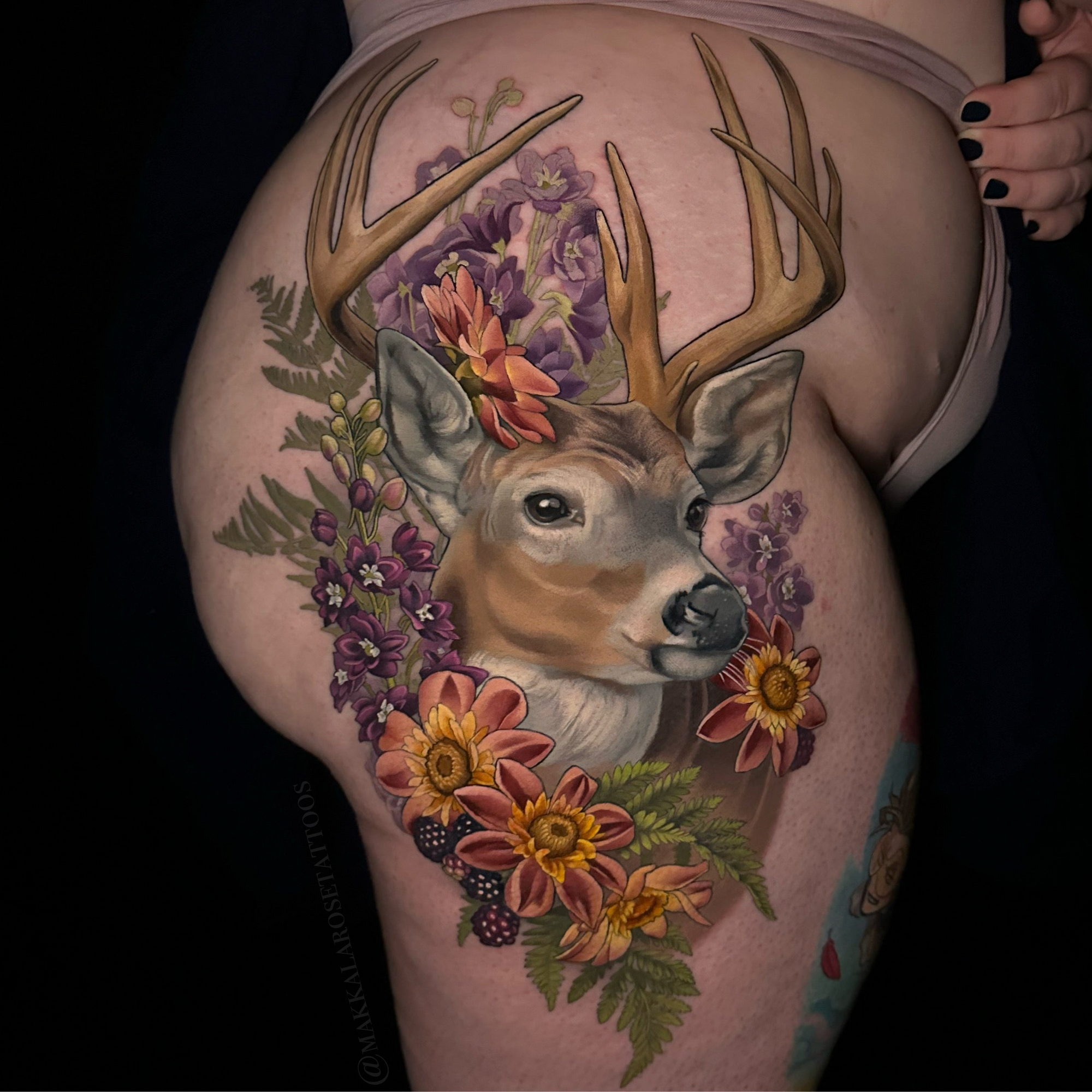 Hip tattoo featuring a deer with florals, ferns  and berries