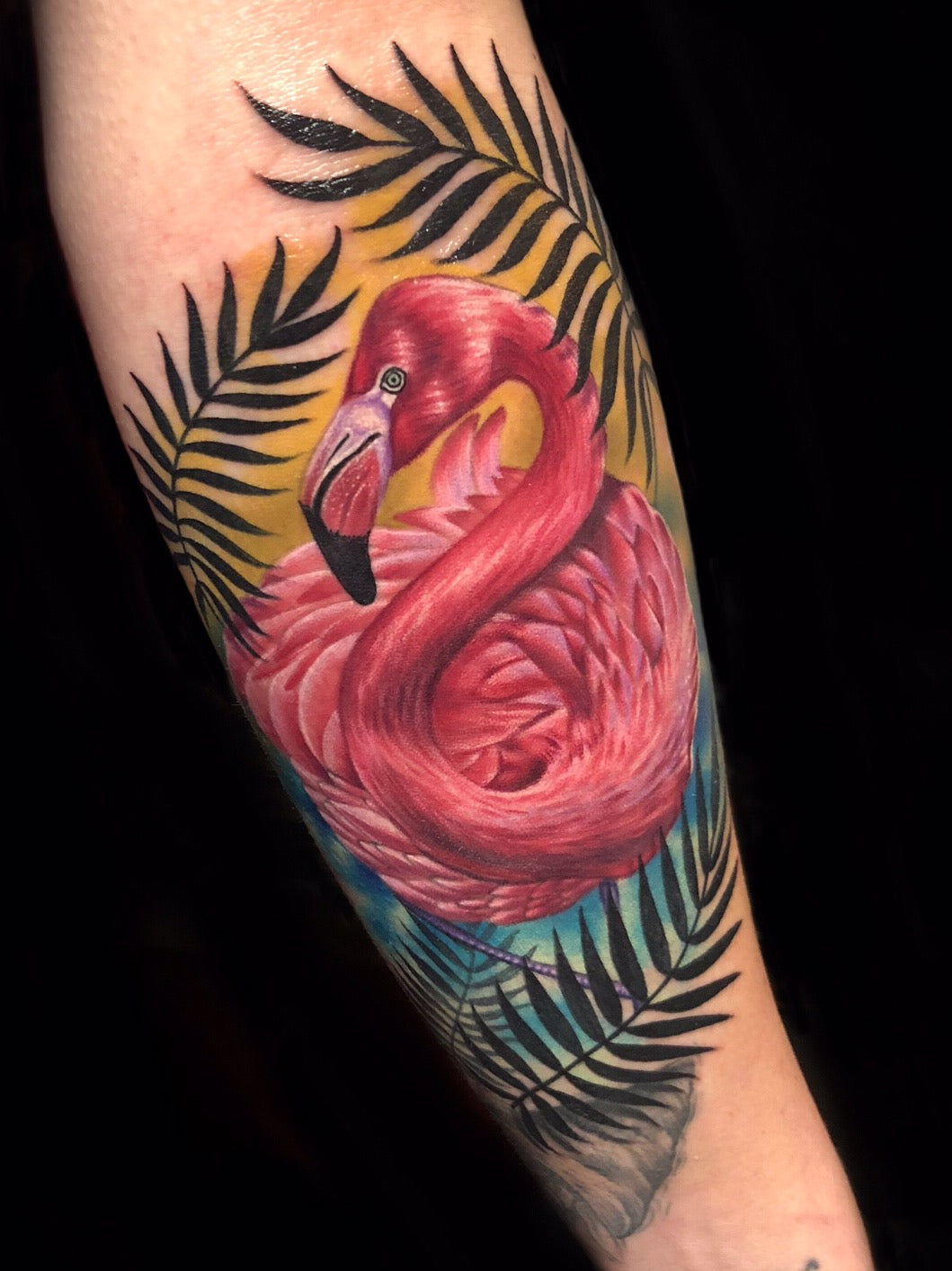 Pink Flamingo realistic tattoo by Megan Massacre at Grit N Glory in New York City. Color realism tattoo of a pink flamingo framed by foliage. 