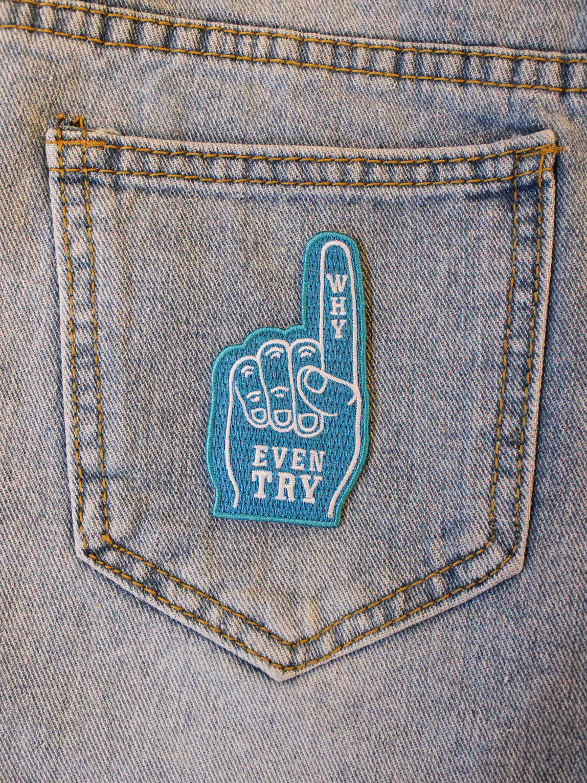 Blue and white foam hand inspired patch photographed on blue denim pocket