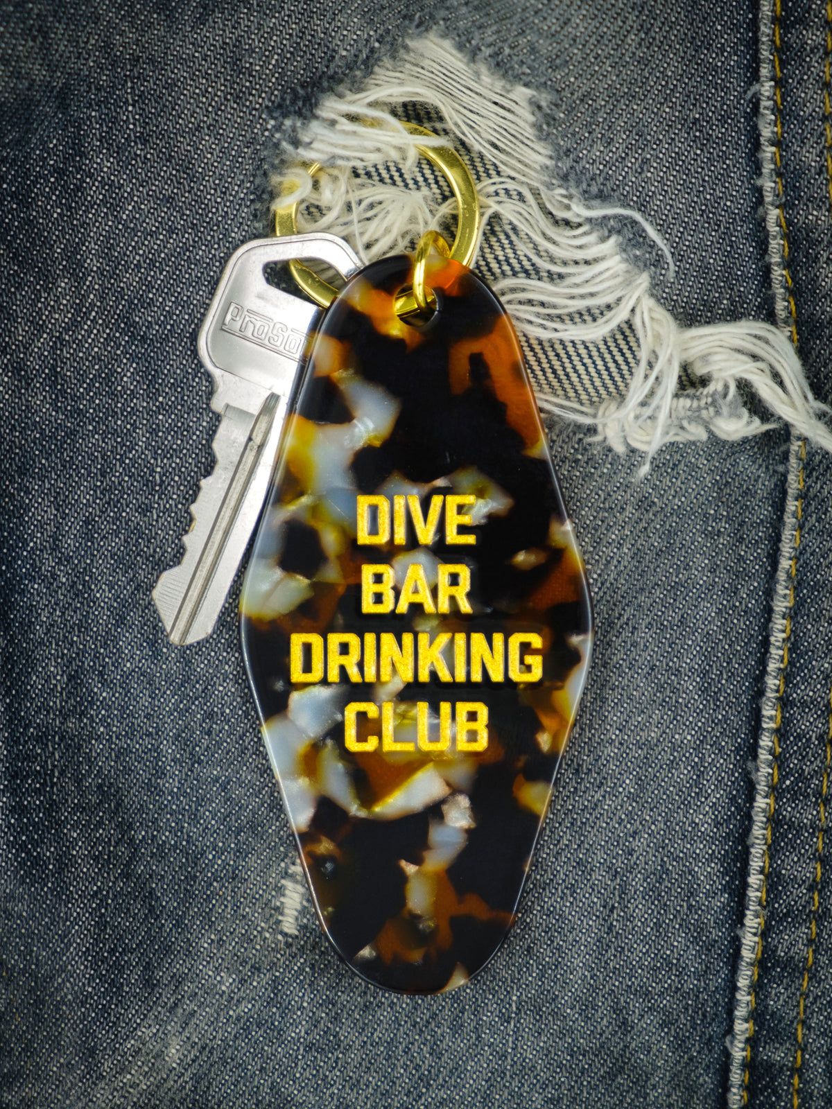 tortoise shell colored motel style keychain photographed on a denim background