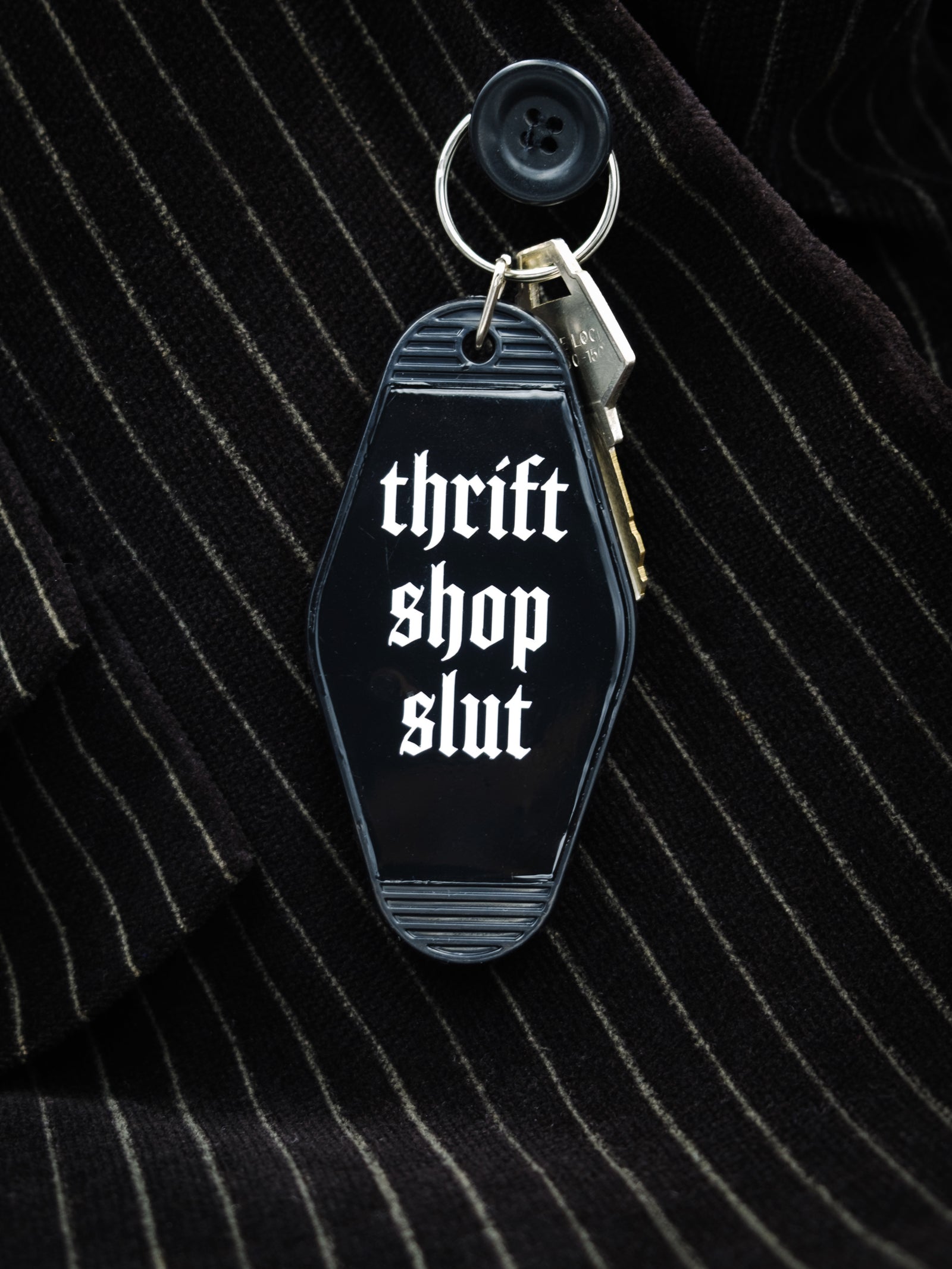 Motel style black keychain that reads "thrift shop slut" in white