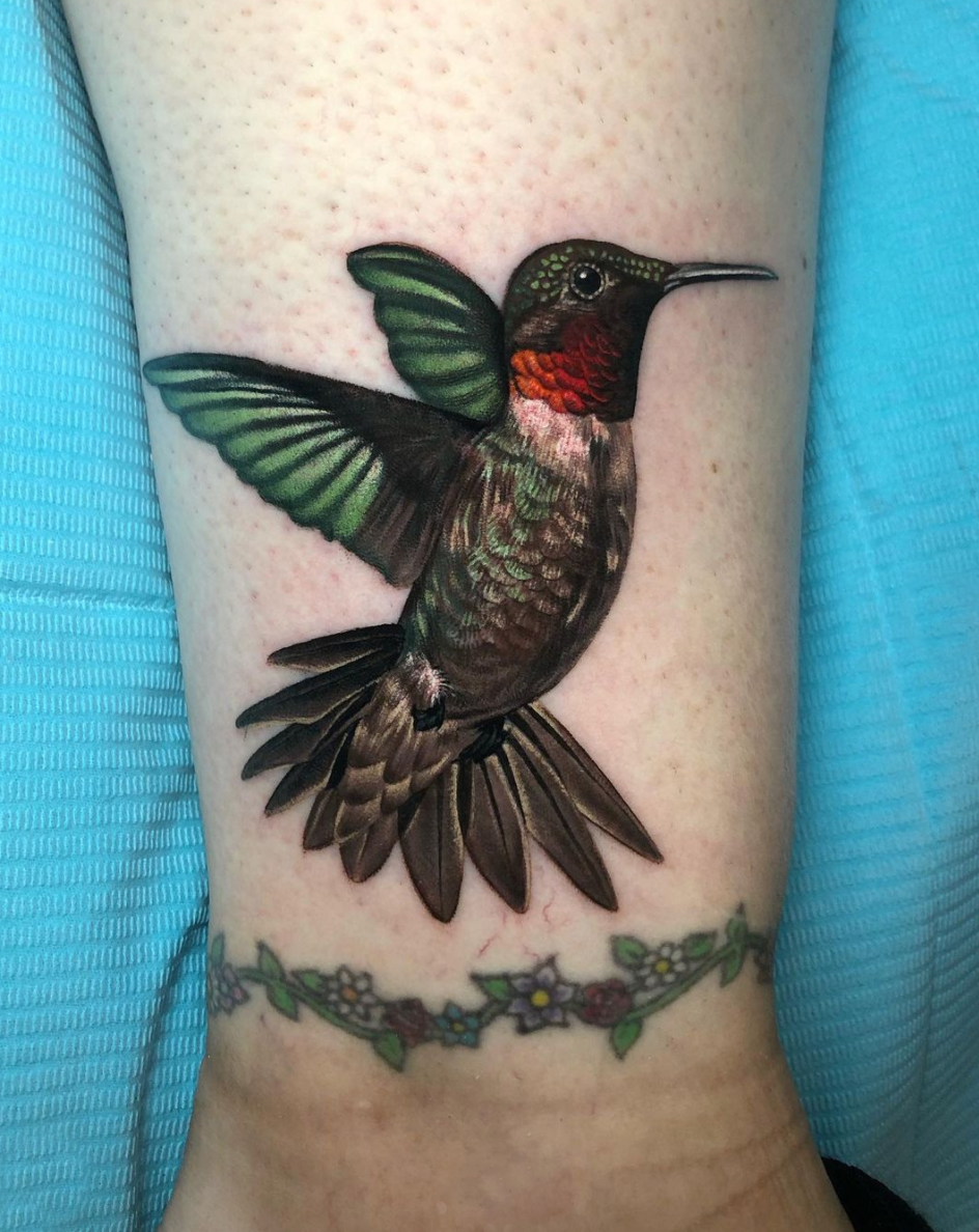 Color realism hummingbird in flight cover up ankle tattoo by Megan Massacre at Grit N Glory in NYC.  