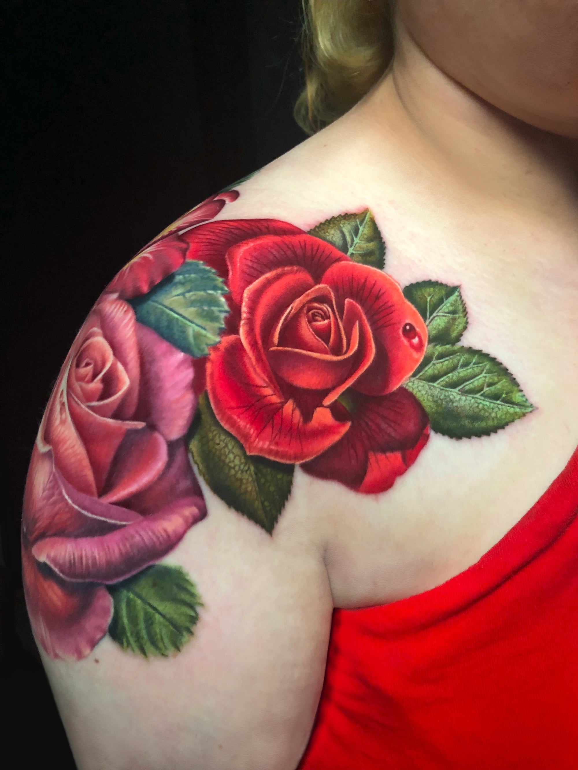 Color realism pink and red roses with green leaves shoulder tattoo by Megan Massacre. 