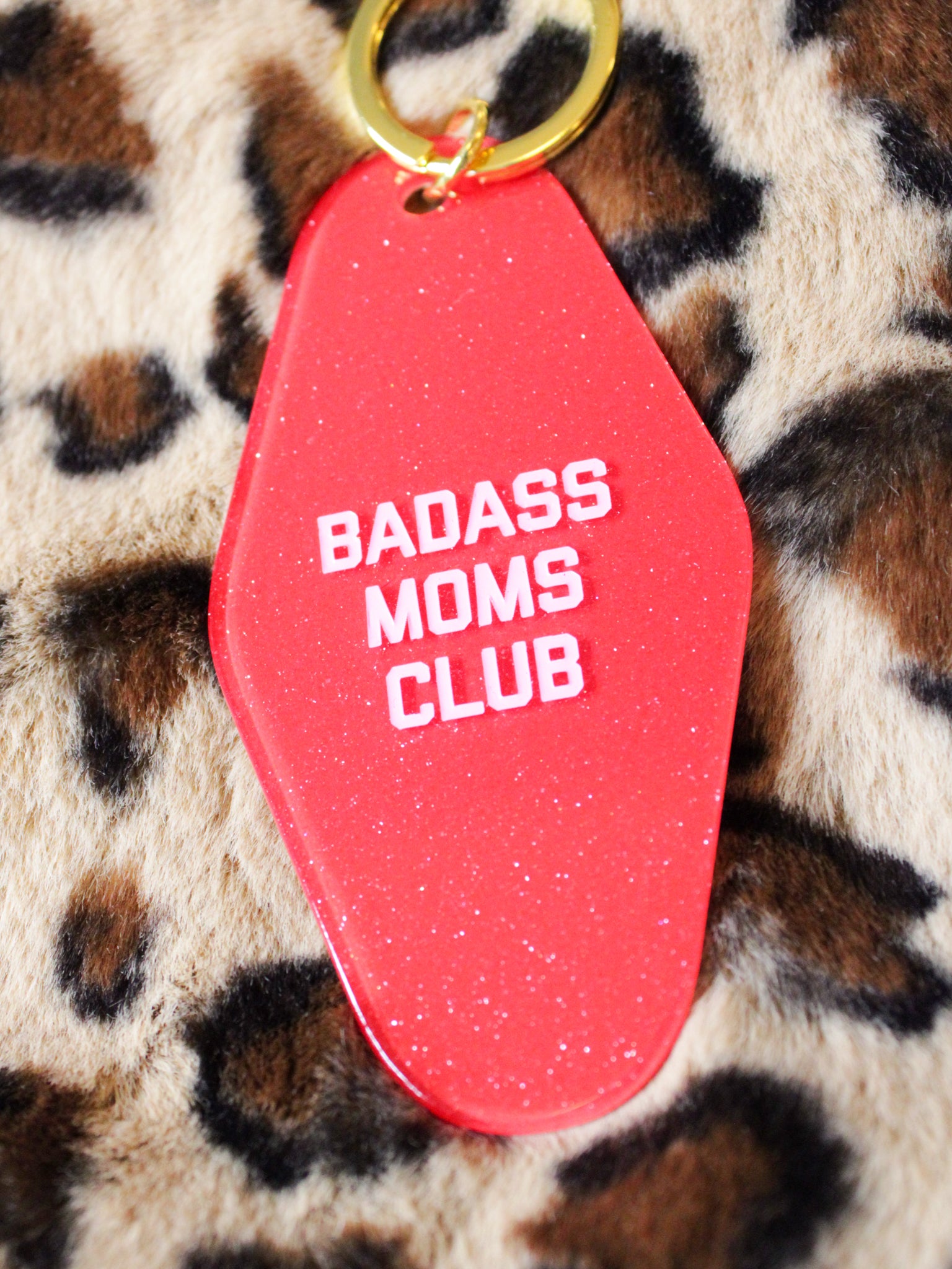 red, glittery keychain reads "badass moms club"