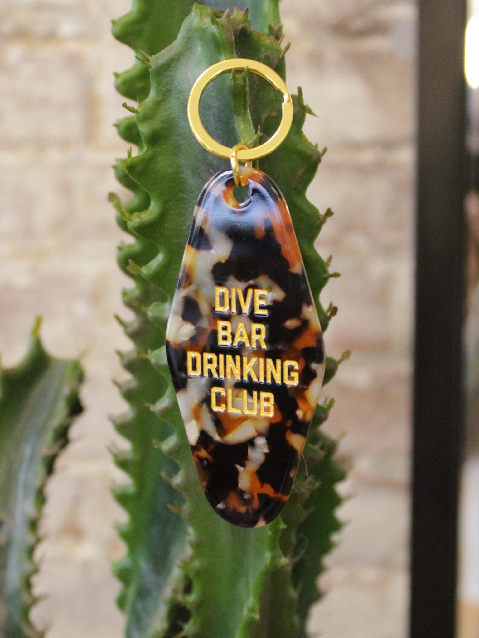 tortoise colored motel style keychain reads "dive bar drinking club"